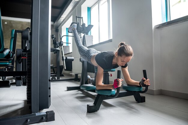 Cliente joven deportista está entrenando para conseguir un estómago plano en el gimnasio