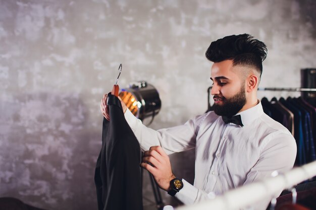 Cliente masculino buscando una chaqueta en la tienda de ropa de hombres.