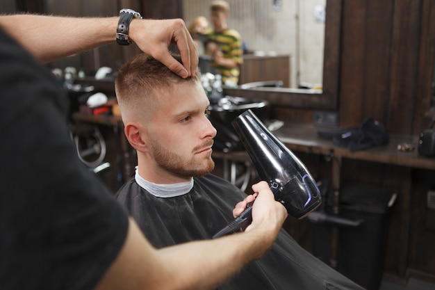 Cliente masculino cortarse el pelo en la barbería