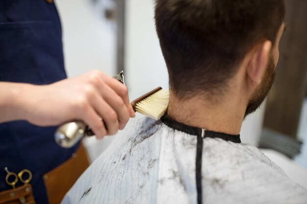 cliente masculino e barbeiro a limpar o cabelo do pescoço