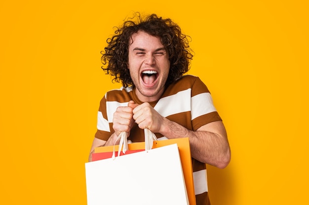 Cliente masculino emocionado con bolsas de papel