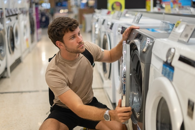 Cliente masculino inspeccionando lavadora