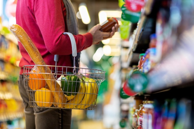 Cliente masculino irreconhecível comprando comida na loja