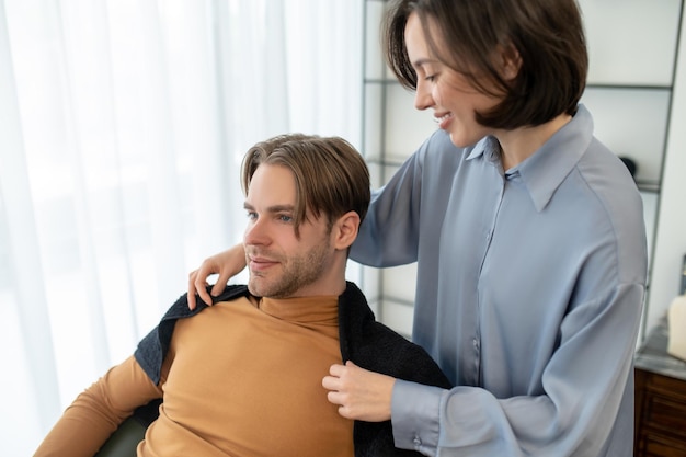 Cliente masculino sentado en la silla en el salón de peluquería