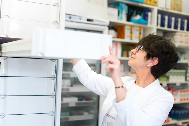 Cliente de mujer de mediana edad en la farmacia en busca de medicamentos