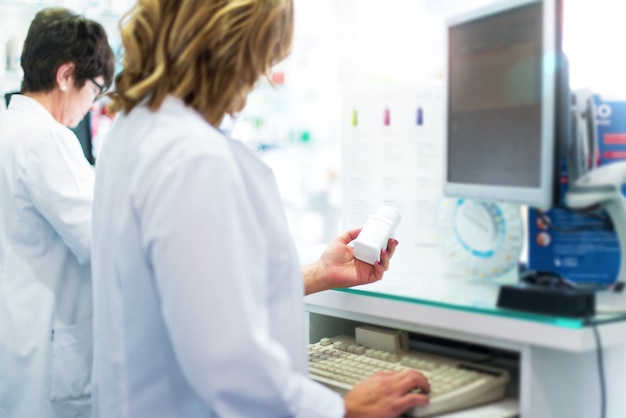 Cliente de mujeres en la farmacia que vende medicamentos a los clientes