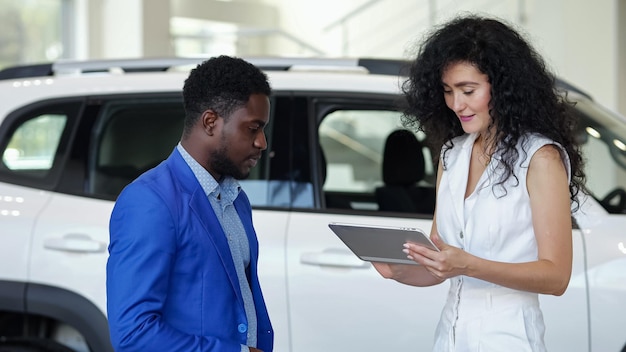 Cliente mulher assina contrato de venda de carro eletrônico em tablet