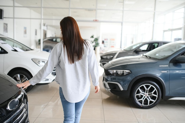 Cliente mulher feliz e amigável cliente compradora mulher cliente escolhe automóvel quer comprar automóvel novo
