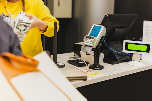 Cliente mulher pagando via cartão de crédito usando tecnologia NFC em shopping