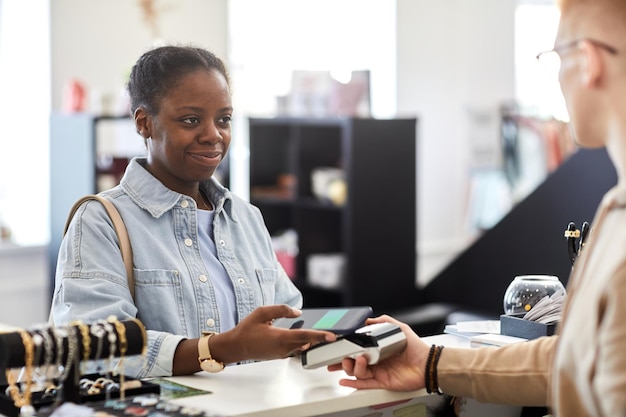 Cliente pagando em loja de roupas via cartão de crédito