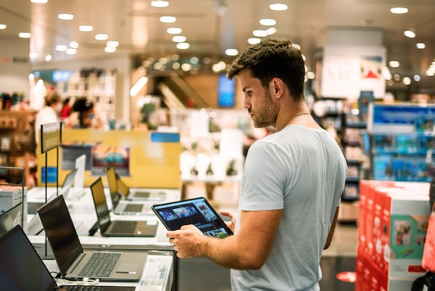 Cliente que elige una computadora portátil en la tienda