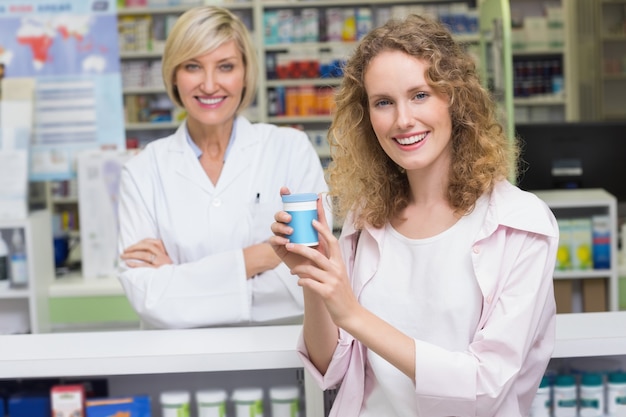 Cliente que mostra o frasco de medicamentos