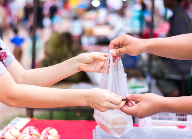 Cliente que paga la factura en efectivo en el mercado al aire libre