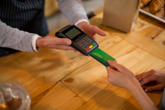 Foto cliente que realiza el pago con tarjeta de crédito en el mostrador