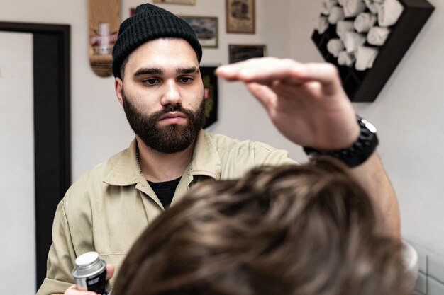 Foto el cliente recibe un corte de cabello y peinado en un salón de belleza. barber atiende al cliente.