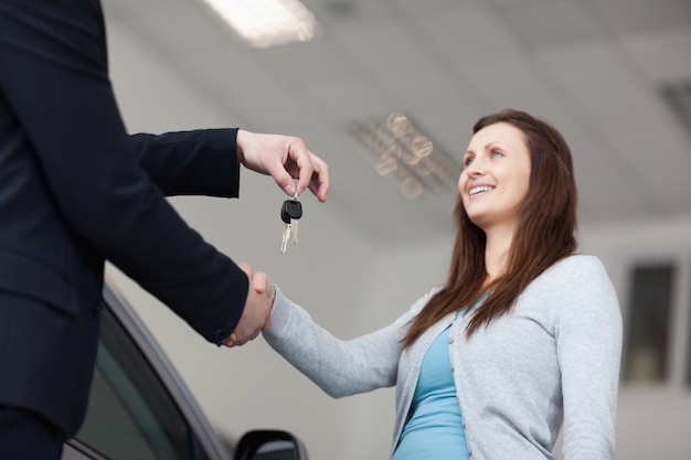 Cliente recibiendo las llaves del auto mientras agita la mano