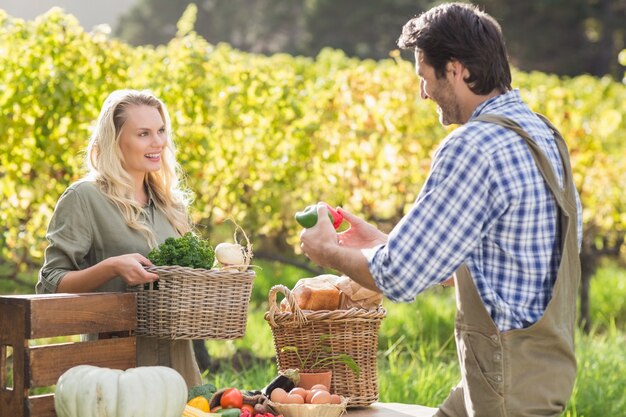 Cliente rubio sonriente que compra verduras