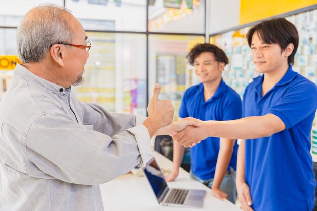 El cliente satisfecho con el servicio del personal de ventas termina el trato a buen precio y se da la mano