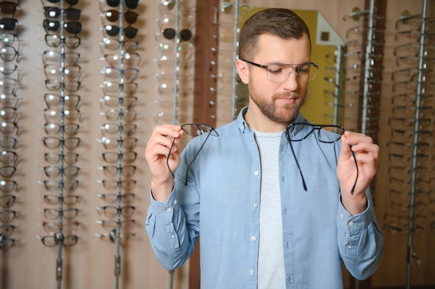 Cliente satisfecho Vista por encima del hombro de un joven cliente feliz con anteojos nuevos