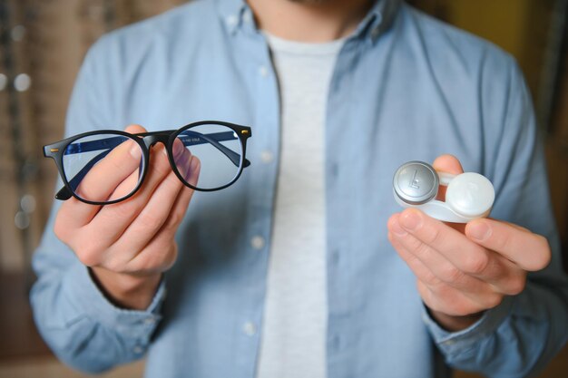 Foto cliente satisfecho vista por encima del hombro de un joven cliente feliz con anteojos nuevos