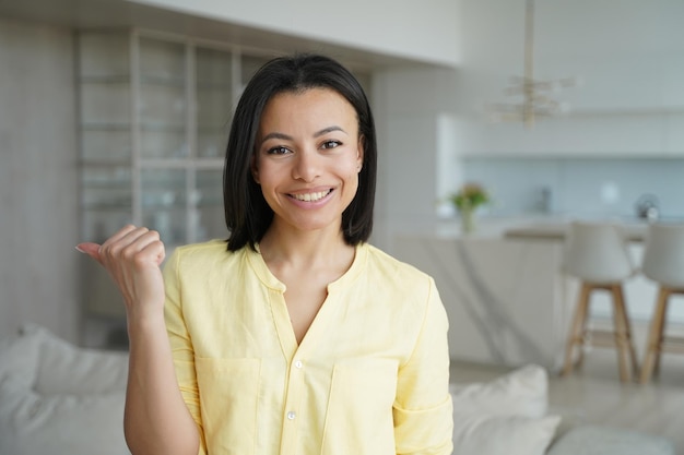 Cliente satisfeito inquilino feminino apontando de lado recomenda serviço de aluguel de casa em casa