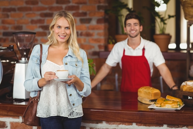 Cliente sonriente que sostiene una taza de café