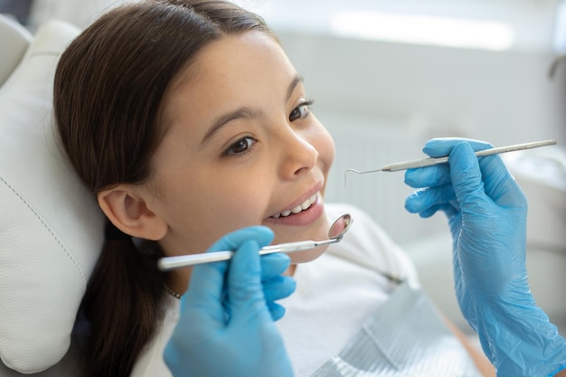 Cliente sorridente no dentista de procedimento odontológico usando instrumentos odontológicos na clínica odontológica moderna