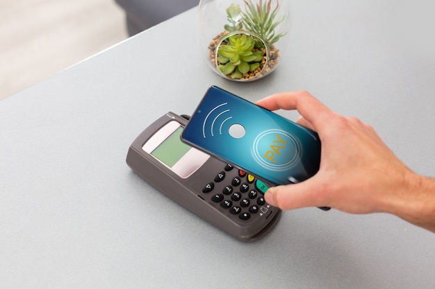 Cliente usando telefone celular para pagar por nfc