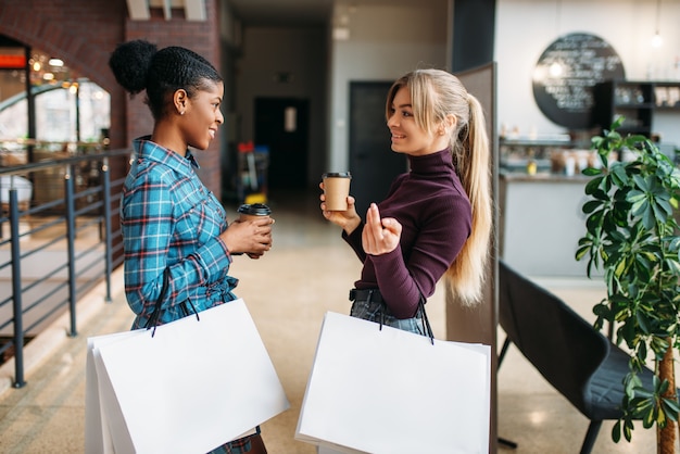 Clientes brancas e negras com sacola de compras