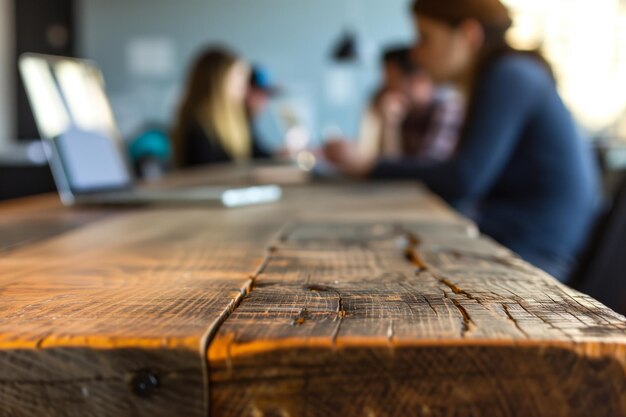 Foto clientes com foco suave na borda da mesa de madeira usando laptops atrás