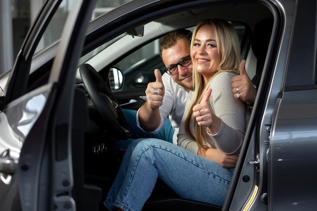 Foto clientes felices en concesionario de automóviles