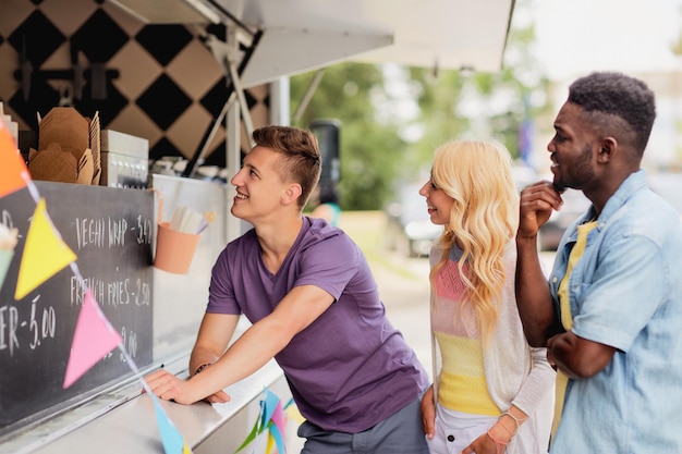 Foto clientes felizes na fila ou amigos no caminhão de comida