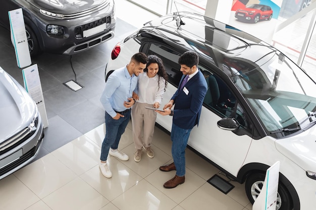 Foto clientes que tienen una conversación con el asistente de ventas que compra la vista del automóvil arriba