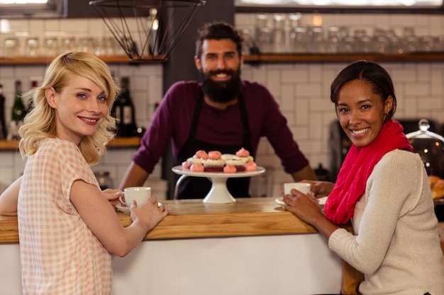 Foto clientes tomando un café con el barman