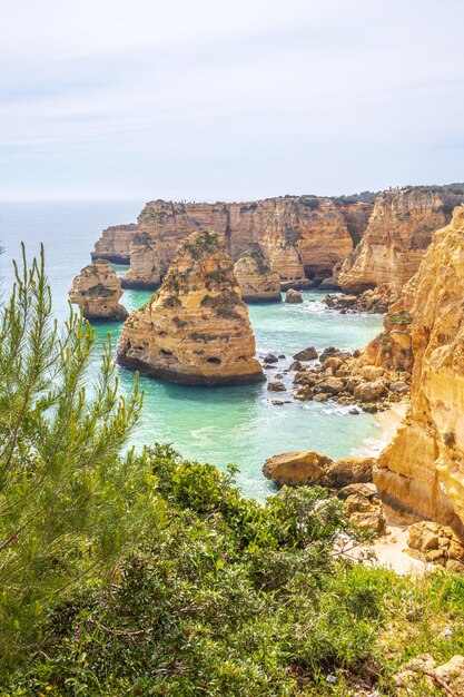 Cliffs y fotografía vertical del océano de Praia da Marinha Algarve Portugal