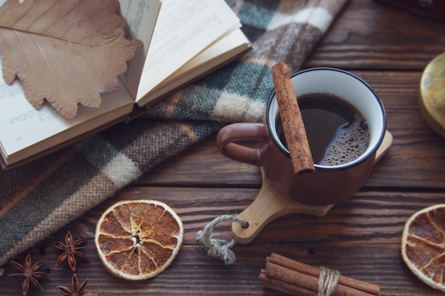 Clima de outono atmosfera de outono Uma xícara de café quente um xadrez xadrez paus de canela anis estrelado um livro em uma janela de madeira vista superior