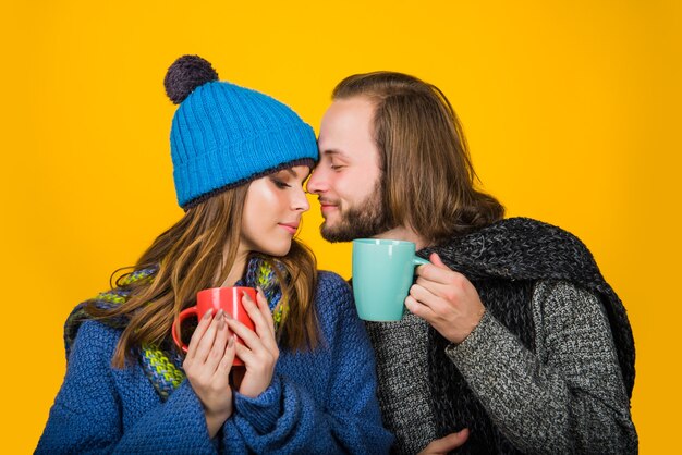 Clima frío. Pareja en ropa de abrigo. Taza con té. Bebida caliente. Mujer en ropa de abrigo tiene una taza de té. Pareja feliz.