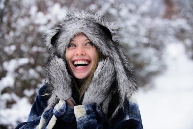Clima de invierno frío hermosa mujer en abrigo cálido sombrero de piel y mitones vacaciones de invierno niña de navidad