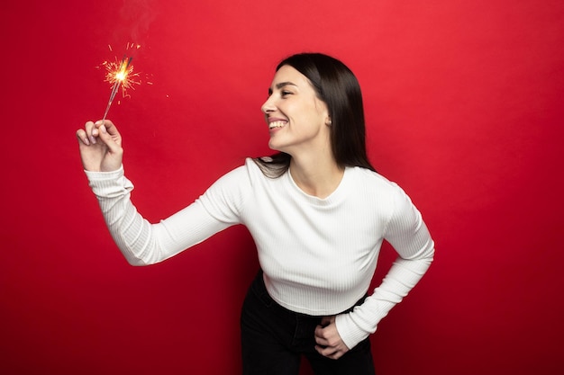 Clima natalino - jovem sorridente com um suéter branco segurando estrelinhas