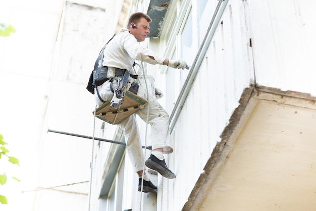 Climberbuilder streicht das Gebäude in einer hellen Farbe in einer Höhe