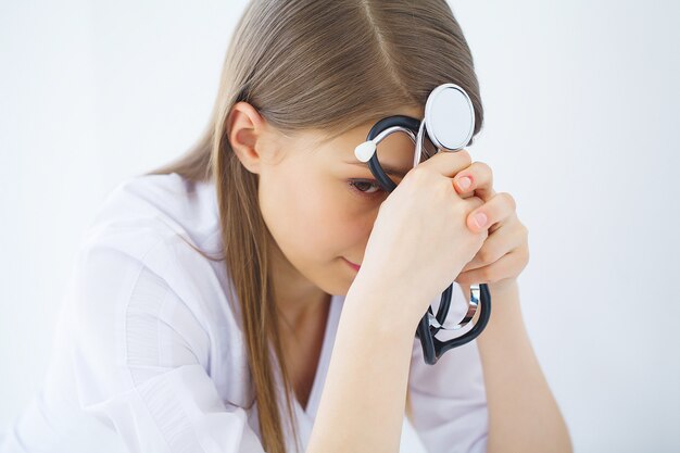 Clínica. retrato de joven médico permanente en consultorio médico