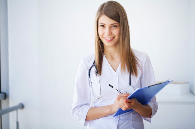 Clínica. Retrato de joven médico de pie en clínica médica