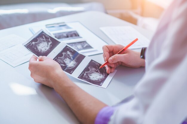 Clínico geral examina imagens de ultra-som do paciente durante uma verificação de saúde e consulta. cuidados de saúde e medicina. diagnóstico e tratamento da doença