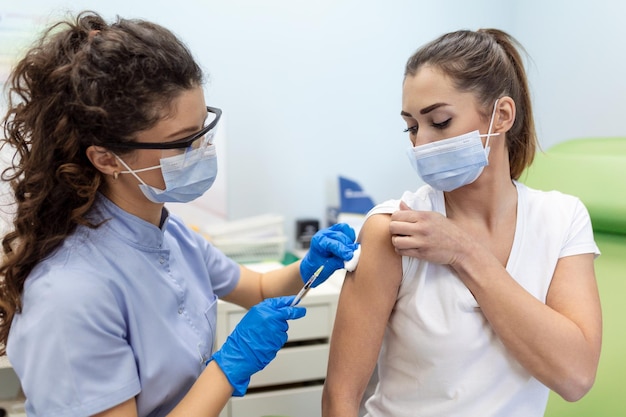 Clínico geral vacinando paciente no hospital com espaço de cópia Médico dando injeção para mulher Enfermeira segurando seringa e usando algodão antes de fazer a vacina Covid19 ou coronavírus