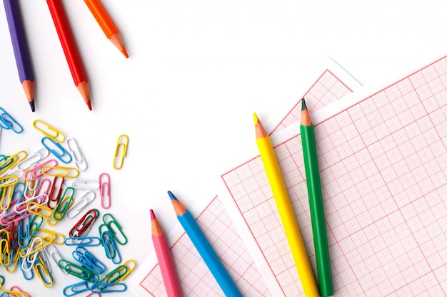 Clip de oficina y lápices de colores sobre fondo blanco.