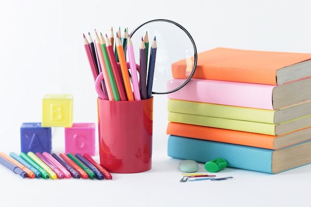 Clip de papel de lupa y útiles escolares en la foto de fondo blanco con espacio de copia