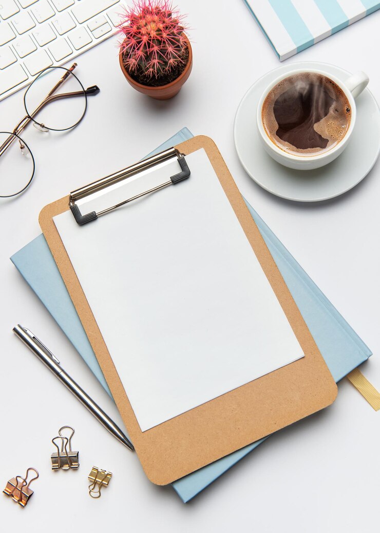 Foto clipboard con papel en blanco cactus de café y suministros de oficina en el escritorio blanco