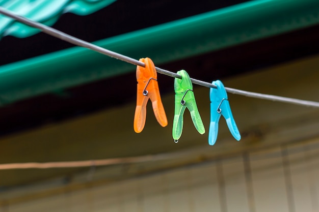 Clips multicolores para lavar la ropa en una tira de cable al aire libre.