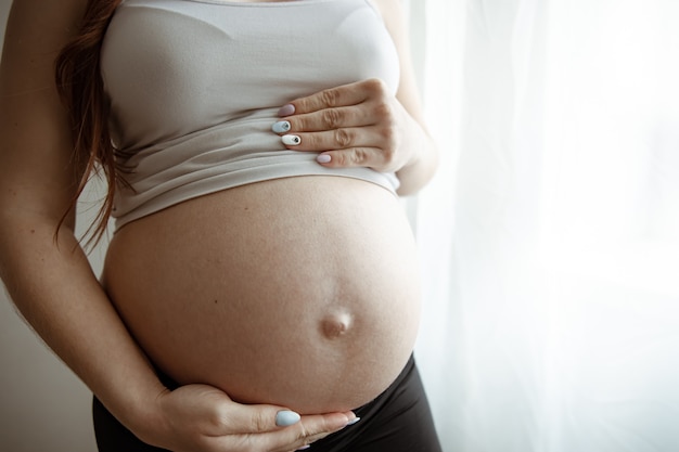 Foto close da barriga nua da gestante nos últimos meses de gravidez.