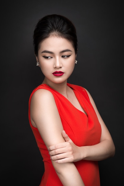 Close da bela garota sexy com maquiagem brilhante e lábios vermelhos. Mulher asiática da moda beleza.